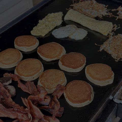 pancakes, eggs, and bacon on a griddle