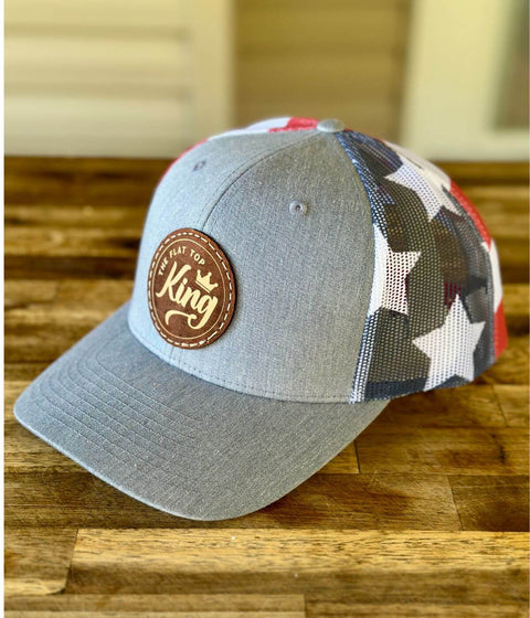 Gray cap with star pattern and leather patch on a wooden surface