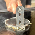 burger press with FTK engraved on it