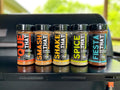 Five bottles of seasoning on a grill with a blurred outdoor background